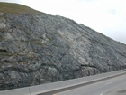 I 26 Tn-NC border road cut exposing a mix of metamorphosed sedimentary rocks intruded by granite.  The ages and names of the units involved may determined from local roadside maps of the geology