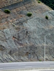 Pound Gap where base of the visible portion this road cut marks the top of the Upper Devonian Bedford and Berea Sequence that are represented by inter-bedded siltstones and sands enclosed and inter-bedded with shale. This in turn is capped by the Lower Mississippian Sunbury Shale that is locally coffee colored. At the top of the outcrop (between the lower two green bushes) is Mississippian Grainger Formation which is composed of alternating relatively continuous to occasionally shallowly channeled beds of sand with uniform sharp bedding planes and shale; both lithologies vary in thickness and the sands often exhibit Bouma sequences suggesting deposition from turbidite currents that were active over a mid to outer fan setting. This portion of the formation is shale rich and probably from a deeper water setting and a more distal portion of the fan