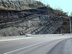 Pound Gap where most of the photograph is of the Mississippian Grainger Formation that is here composed of alternating relatively continuous to occasionally shallowly channeled beds of sand with uniform sharp bedding planes and shale; both lithologies vary in thickness and the sands often exhibit Bouma sequences suggesting deposition from turbidite currents that were active over a mid to outer fan setting. The lower portion of the formation is shale rich and probably from a deeper water setting and a more distal portion of the fan. The top of the photograph is marked by the overlying Lower Mississippian Newman Limestone Formation