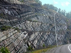 Pound Gap where most of this photograph is of the middle and lower portions of the Mississippian Grainger Formation; here composed of alternating relatively continuous to occasionally shallowly channeled beds of sand with uniform sharp bedding planes and shale; both lithologies vary in thickness and the sands often exhibit Bouma sequences suggesting deposition from turbidite currents that were active over a mid to outer fan setting. The lower portion of the formation is shale rich and probably from a deeper water setting and a more distal portion of the fan