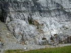 Storm waves probably eroded and reworked these sediments that accumulated across the depositional surface of this shelf and induced the shallow water limestones in the Lower Mississippian Newman Limestone Formation to form their irregular character, while local tidal currents may have caused the development of low angle cross beds and migrating carbonate low relief mound margin clinoforms that moved across this setting. Unit 105 shown in center is base of 105 and is 23 feet thick ending at dark base of unit 104, see the measured Geological Section, Kentucky Geological Survey Field Trip Guide 1998. Number 105 is top of 106 which has bottom 6 feet down and highlighted by small caves