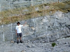 Details of the Lower Mississippian Newman Limestone Formation some tens of feet above its erosional contact with the Mississippian Grainger. Note the chocolate colored silty dolomite horizon interbedded with the limestone. The limestone have irregular but sharp bedding planes and clinoforms. The scale is Nassir Alnaji when he was a graduate student