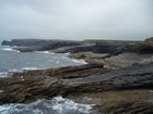 Eroded bedding planes of the Namurian deepwater sediments of the Ross Formation exposing rippled and scoured surfaces of the sediments of this deepwater system. Fisherman's Point ledge in the background to the left and northwest.