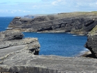 Cliffs and eroded bedding planes of the coastal monocline of Namurian deepwater sediments of the Ross Formation. Fisherman's Point ledge is situated to the left background to north. In foreground are bedded and slumped sediments of the Ross Formation.