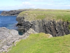 Moniclinically folded deepwater sediment of the Upper Carboniferous Namurian Ross Sandstone just south of Fisherman's Point, which is visible in background to the left and north-westward.