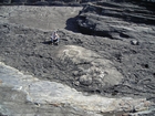 Exposures of a bedding plane surface in the Upper Carboniferous Ross Sandstone in which sand volcanoes overly local slumps of the deepwater sediment close to at Fisherman's Point. Volcanoes are built by sands transported by water released when the slide compacted beneath its own weight. Flank slopes reach 15° (Gill & Kuenen, 1958) with slightly concave outer slopes exhibiting flow runnels and ridges down the flanks with a central sand filledcrater (Strachen, 2002).