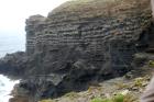 Cliff at Tullig Point with mix of Tullig and Gull Island Formations. Note delta front silts and muds above, while below are Gull Island Formation mixed channel sands and lobes and large deformational structures interpreted to have been transported downslope from a deltaic source above. Note large slump filled gauges cut into rhythmic slope deposits of silt and mud.