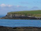 West end of Kilbaha Bay with outcrop of Mid-Ross Sandstone Formation in the background and in the forground the wave cut pavement of the intertidal zone.