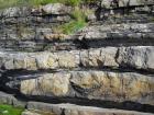 Interbedded channeled sand lobes and overbank shales of the Ross Formation on the West side of Kilbaha Bay. Base of section to left is the eroded edge of a megaflute to left and the onlapping fill.