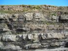 Interbedded channeled sand lobes Ross Fm West Kilbaha Bay and overbank shales. Note soft sediment deformation and scouring at the base of the channeled sand lobes. The scallopped character of some of the sands suggestive of megaflutes scouring their surfaces.