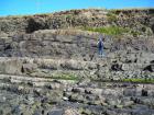 Amalgamated sands of channel margin in the channeled lobe of the Ross Formation of West Kilbaha, over thinner interbedded channel sand lobes. At top of section is Pleistocene glacial drift.