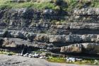 At base of the ledge in the foreground is a chute scour filled by deepwater interbeds of thin sands and shale. The top of section exhibits sand lobes and interbeds of shale,