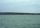 East end of the Kilclogher Cliffs exposes the deepwater sandstone lobes of the Ross Formation. Thicker bedded amalgamated channeled sands of the upper section represent the proximal axies of deepwater lobes interbedded with lobe and channel wing sands. Westward the lower thin bedded portion of the section are distal deepwater lobes that overlie a thicker bedded amalgamated channeled sand. On right and east is a monocline dipping south.