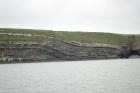 East end of the Kilclogher Cliffs exposing deepwater sandstone lobes of the Ross Formation. At the base of the section are thinner bedded more distal portions of lobes. Above in grass cover and to the left are thicker bedded amalgamated channeled sands more proximal to the axies of deepwater lobes.