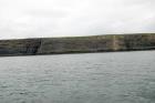 Kilclogher Cliffs exposing deepwater sandstone lobes of the Ross Formation. At the base of the section are thinner bedded more distal portions of lobes subdivided by a thicker amalgamated channel sand. Above in grass cover to the left or west are thicker bedded amalgamated channeled sands more proximal to the axies of deepwater lobes.