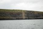 East end of the Kilclogher Cliffs exposing deepwater sandstone lobes of the Ross Formation. At the base of the section are thinner bedded more distal portions of lobes subdiveded by a thicker bedded amalgamated channeled sand. Above in grass cover are thicker bedded amalgamated channeled sands more proximal to the axies of deepwater lobes.