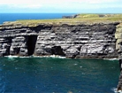 The Ross Formation of Loop Head is here expressed as turbidite sheet sands that accumulated as deepwater fan lobes that were dissected by sparse shallowly incised channels. As Elliot (2000) records these are the thicker bedded, high net-to-gross, sheet turbidites of the lower part of the Ross Sandstone Formation turbidite system. The height of these cliffs is between 45-50 m. Note the shaley partings that may compartmentalize these sands and seperate them in terms of their reservoir quality from those above. Shallow though the channeling is, it may enhance vertical reservoir continuity between the stacked sheets