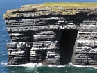 The Ross Formation of Loop Head is here expressed as turbidite sheet sands that accumulated as deepwater fan lobes that were dissected by sparse shallowly incised channels. As Elliot (2000) records these are the thicker bedded, high net-to-gross, sheet turbidites of the lower part of the Ross Sandstone Formation turbidite system. The height of these cliffs is between 45-50 m. Note the shaley partings that may compartmentalize these sands and seperate them in terms of their reservoir quality from those above. Shallow though the channeling may be it may enhance vertical reservoir continuity between the stacked sheets