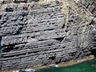 The Ross Formation of Loop Head is here expressed as turbidite sheet sands that accumulated as deepwater fan lobes that were dissected by sparse shallowly incised channels. As Elliot (2000) records these are the thicker bedded, high net-to-gross, sheet turbidites of the lower part of the Ross Sandstone Formation turbidite system. The height of these cliffs is between 45-50 m. Note the shaley partings that may compartmentalize these sands and seperate them in terms of their reservoir quality from those above. Shallow though the channeling may be it may enhance vertical reservoir continuity between the stacked sheets