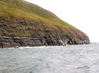 West end of Rehy Cliffs showing a thin bedded inter channel area at western feather edges of deepwater channel wings. Overlying a filled channel in mid section are downlapping clinoformed sands of interior channel margin. Ross Formation sands probably in mid fan position on edge of the fan body.