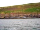 Rehy Cliffs exposing two channelled amalgamated deepwater fills, offset from each other. The lower channel is just above present sea level, highlighted by gull droppings. Ross Sandstone probably in mid fan position towards center of fan body.