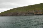 Rehy Cliffs exposing two channelled amalgamated deepwater fills, offset from each other. The lower channel is just above present sea level, highlighted by gull droppings. Ross Sandstone probably in mid fan position towards center of fan body.