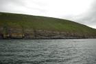 Rehy Cliffs exposing two channelled amalgamated deepwater fills, offset from each other. The lower channel is just above present sea level, highlighted by gull droppings. Ross Sandstone probably in mid fan position towards center of fan body.