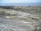 Irregularly bedded sandstone sheets of deepwater lobes of Ross Formation with some of the irregular character representing the cross sections of megaflute fill.