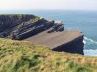 Top of cliff exposes well sorted and channeled sands of the delta front distributary mouth bars. In lower part of cliff are Tullig Formation rythmic silts and mud with some sands of deeper water delta front. Sediments are of Upper Carboniferous or Namurian age.