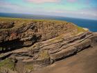 Top of cliff exposes well sorted and channeled sands of the delta front distributary mouth bars. In lower part of cliff are Tullig Formation rythmic silts and mud with some sands of deeper water delta front. Sediments are of Upper Carboniferous or Namurian age.