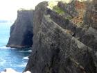 Top of cliff exposes well sorted and channeled sands of the delta front distributary mouth bars. In lower part of cliff are Tullig Formation rythmic silts and mud with some sands of deeper water delta front. Sediments are of Upper Carboniferous or Namurian age.